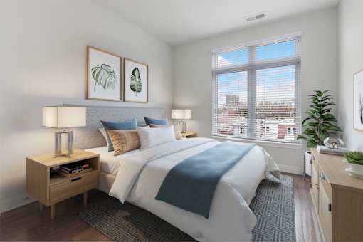 A bedroom with a large bed and a window overlooking a cityscape.