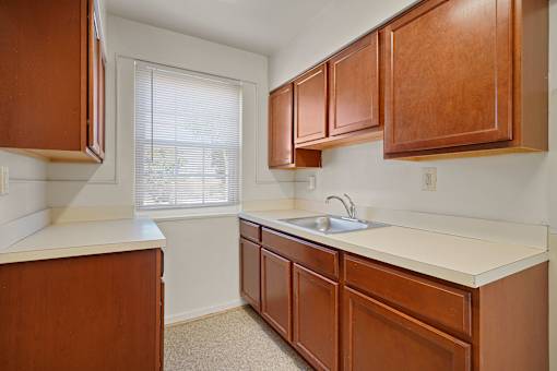 A kitchen with brown cabinets and a white countertop.
