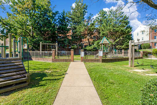 A park with a playground and a wooden bench.