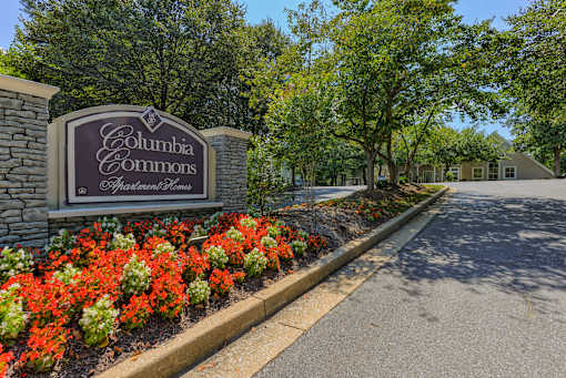 a sign commons sits in front of a garden of flowers