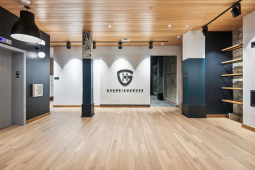 a large room with wood floors and a wall with a logo on it