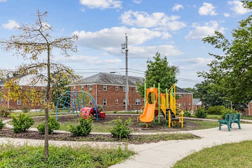 a playground in a park in front of a brick building
