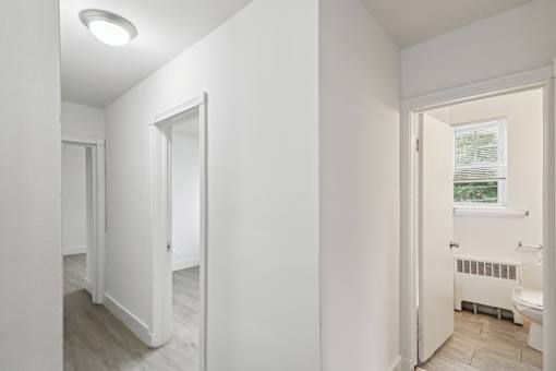 a living room with white walls and a door to a bathroom