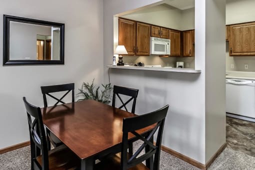 a dining room table and a kitchen with a microwave