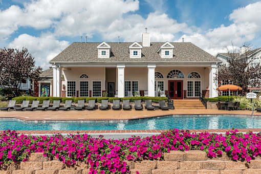 A white house with a pool in front of it.