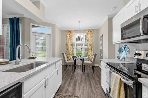 A kitchen with white cabinets and a black stove top oven.