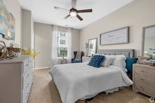 A bedroom with a large bed and a ceiling fan.