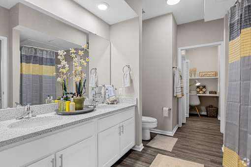 A bathroom with a white vanity and a mirror above it.