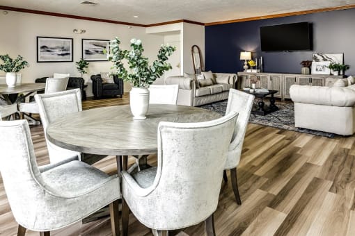 a living room and dining room with white chairs and a table