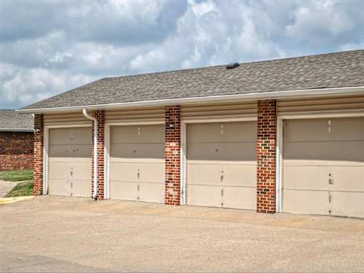 three garage doors on the side of a brick building