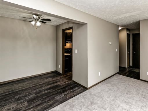 an empty living room with a ceiling fan