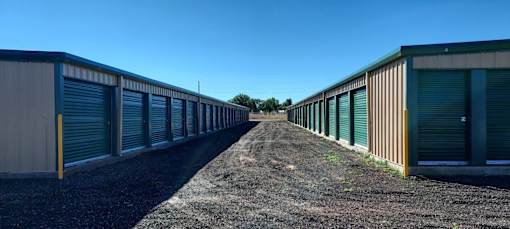a row of storage units with green doors