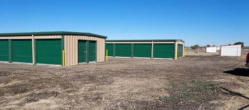 a row of storage units with green doors