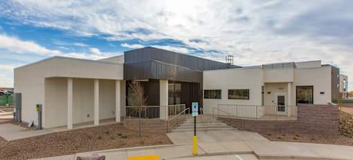 A modern building with a flat roof and a covered walkway.