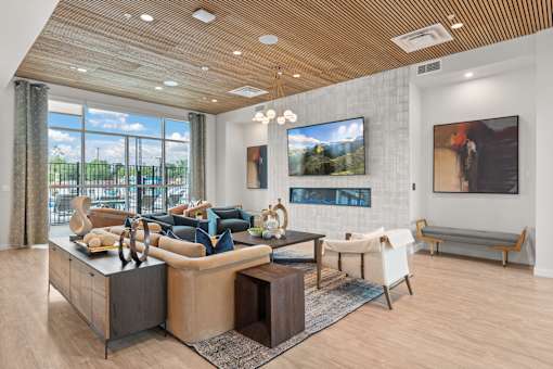 A modern living room with a wooden ceiling and a large window.