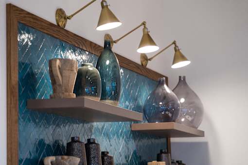 A shelf with a lamp and vases on it.