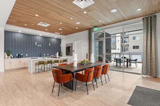 A modern dining room with a long table and chairs.