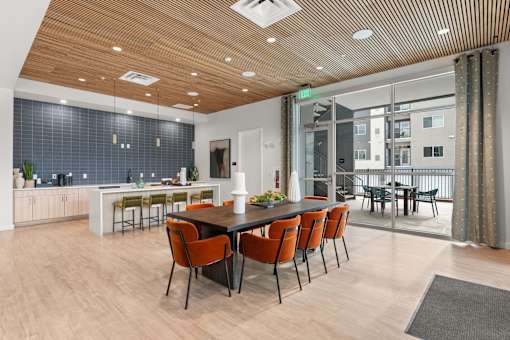 A modern dining room with a long table and chairs.
