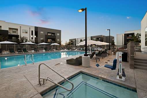 A pool area with a ladder and a sun umbrella.