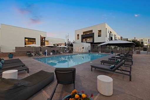 A modern poolside area with lounge chairs and a pool.