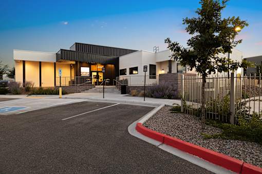 A modern building with a parking lot in front.