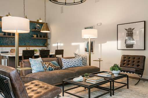 A living room with a brown leather chair and a glass coffee table.