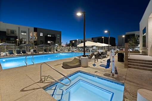 A swimming pool with a ladder and a sun umbrella.