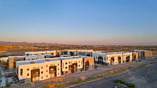 A large building complex with a parking lot in front.