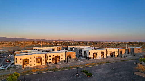 A large building complex with a parking lot in front.
