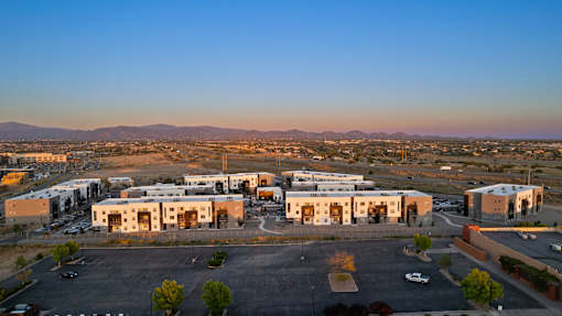 A large industrial building complex with a parking lot in front.
