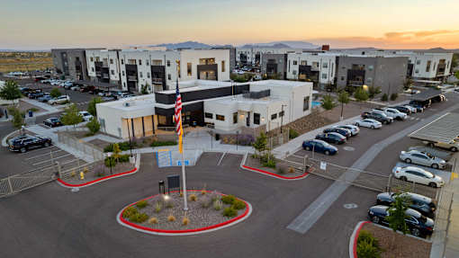 A parking lot with a building and a flag in front of it.