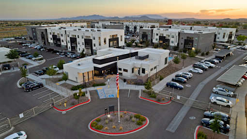A sunset view of a parking lot with a flag pole in the center.