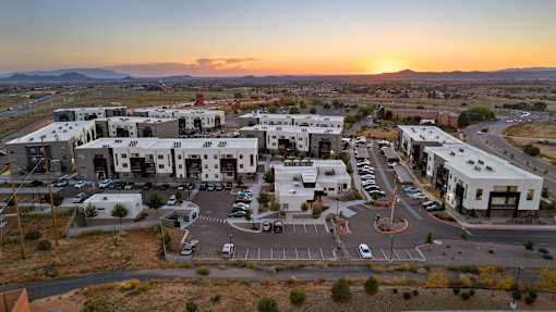 A sunset view of a parking lot and buildings.
