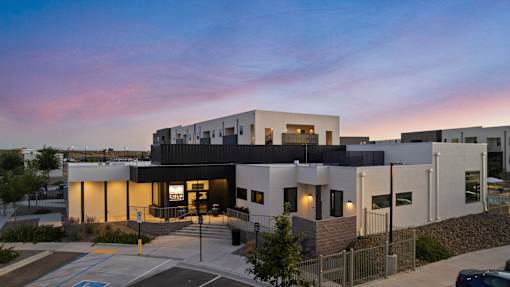 A modern building with a parking lot in front.