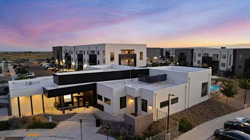 A modern building with a parking lot in front.