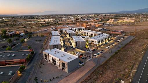A large building complex with a parking lot in front of it.