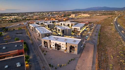 A large building complex with a parking lot in front of it.
