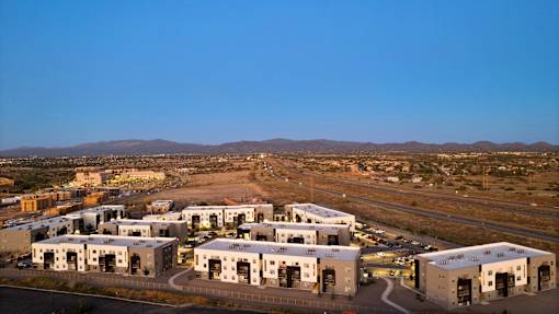 A large building complex with a parking lot in front.