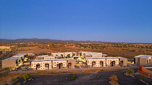 A large industrial building complex with a parking lot in front.
