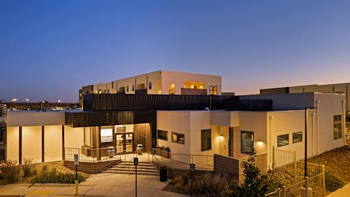 A modern building with a flat roof and a large entrance area.