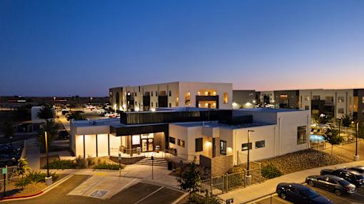 A modern building with a parking lot in front of it.