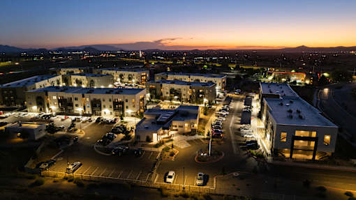 A parking lot is in front of a building with a mountain in the background.