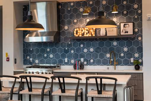 A kitchen with a blue tile backsplash and a sign that says "OPEN".