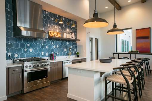 A modern kitchen with a large island and stainless steel appliances.