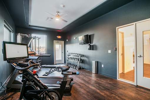 A room with a wooden floor and a wall-mounted TV.