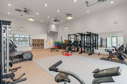 A gym with a variety of equipment including treadmills, weights, and exercise machines.