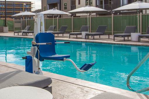 A blue chair is in front of a pool.