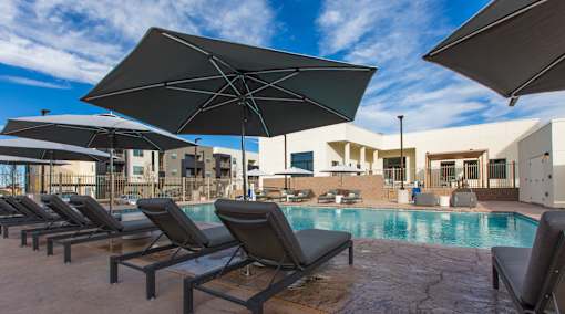 A poolside area with sun loungers and umbrellas.