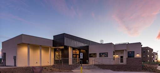 A modern building with a flat roof and a large entrance area.
