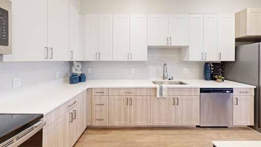 A kitchen with white cabinets and a wooden floor.